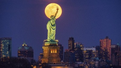 The rising full moon shines behind the Statue of Liberty, Monday evening, March 9, 2020, in New York City. (AP Photo/J. David Ake)