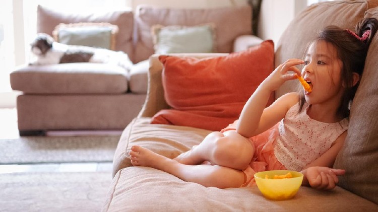 884431564 Sweet baby girl 3-4 year old eating cookies and drinking milk lying in bed close up. Good morning. Breakfast.