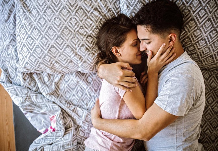 couple Young couple in love lying on bed at home and cuddling, embracing and enjoying weekend together