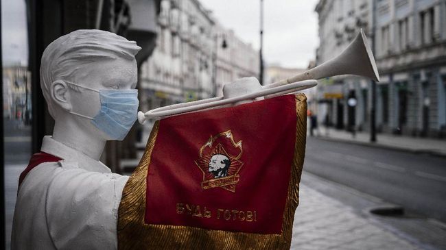 A picture shows a face mask placed on a sculpture of a Soviet pioneer playing a trumpet in front of a closed restaurant on an empty  street of downtown Moscow on March 30, 2020, as the city and its surrounding regions imposed lockdowns today, that were being followed by other Russian regions in a bid to slow the spread of the COVID-19 infection caused by the novel coronavirus. - The enforcement of the strict new rules, which Moscow Mayor suddenly announced for the capital late on March 29, coincide with the beginning of a 