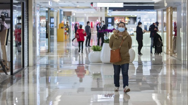 In this photo released by Xinhua News Agency, people wearing protective masks to prevent the new coronavirus outbreak walk on a re-opened shopping mall in Wuhan in central China's Hubei province on Monday, March 30, 2020. Shopkeepers in the city at the center of China's virus outbreak were reopening Monday but customers were scarce after authorities lifted more of the anti-virus controls that kept tens of millions of people at home for two months. (Fei Maohua/Xinhua via AP)