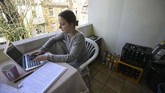 Lana seorang mahasiswa di Dortmund, Jerman, memilih belajar di balkon apartemennya selama pemerintah menerapkan aturan isolasi mandiri demi mencegah penularan virus corona COVID-19. (Ina FASSBENDER / AFP)