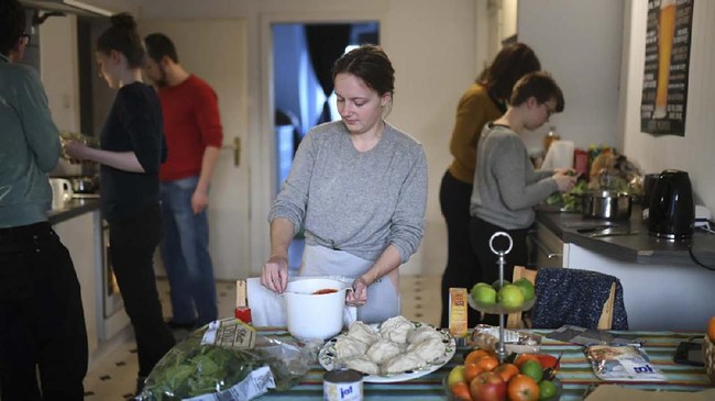 Student Lana (C) and her flatmates prepare self-made pizzas in the kitchen of a flat-sharing in Dortmund, western Germany, on March 27, 2020, amidst the pandemic of the new coronavirus COVID-19. - There's group yoga in the morning, homemade pizza in the evening and always someone to borrow toilet paper from. For the six German students sharing a flat in Dortmund, the coronavirus lockdown has its unexpected upsides. With no classes to attend and their social lives interrupted, the four young women and two men sharing a three-bedroom flat are suddenly enjoying a lot of quality time, as they join millions of Germans in staying home to slow the pandemic. (Photo by Ina FASSBENDER / AFP)