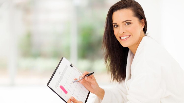 elegant young woman planning her pregnancy in bedroom at home