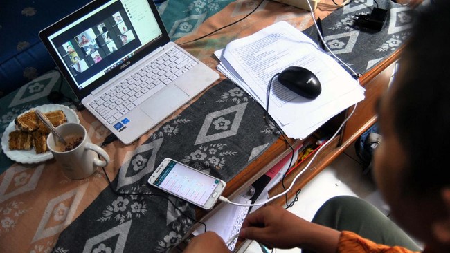Guru SD berkomunikasi dengan siswa saat proses belajar mengajar (PBM) melalui aplikasi media daring dirumahnya di Kelurahan Bubulak, Kota Bogor, Jawa Barat, Rabu (1/4/2020). Dinas Pendidikan Jawa Barat menginformasikan pengawas dan pihak sekolah untuk melaksanakan PBM dari rumah fokus pada pendidikan dan kecakapan hidup antara lain mengenai pandemi virus Corona (COVID-19) serta melalui pembelajaran media daring dengan variasi sesuai peserta didik. ANTARA FOTO/Arif Firmansyah/foc.