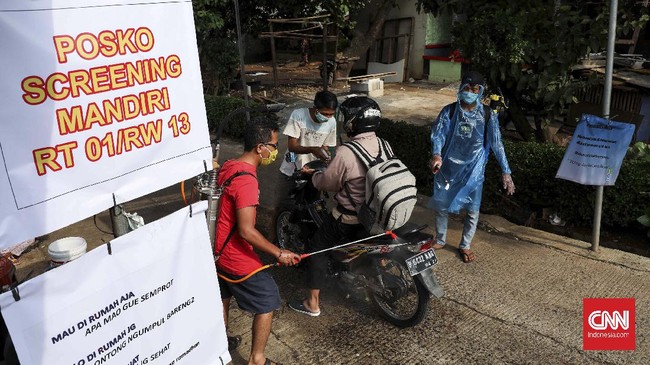 Warga dengan swadaya membuat posko sterilisasi penyemprotan disinfektan bagi warga maupun pendatang yang akan masuk ke pemukiman mereka. CNNIndonesia/Safir Makki