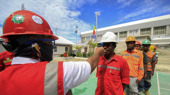 Petugas mengukur suhu pekerja sebelum beraktivitas di Venue Aquatic Kampung Harapan, Sentani, Jayapura, Papua, Rabu (01/4/2020). Pemprov Papua memperpanjang pembatasan sosial hingga 13 April 2020 untuk memutus penyebaran virus corona (COVID-19) di Papua. ANTARA FOTO/Gusti Tanati/hp.