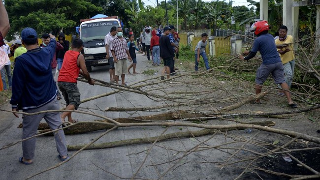 Warga melakukan aksi menutup jalan menuju ke pemakaman Macanda di Kecamatan Somba Opu, Kabupaten Gowa, Sulawesi Selatan, Kamis (2/4/2020). Penutupan akses jalan yang dilakukan sejumlah warga yang bermukim di sekitar pemakaman Macanda tersebut sebagai bentuk penolakan terhadap pemakaman jenazah pengidap COVID-19. ANTARA FOTO/Abriawan Abhe/foc.