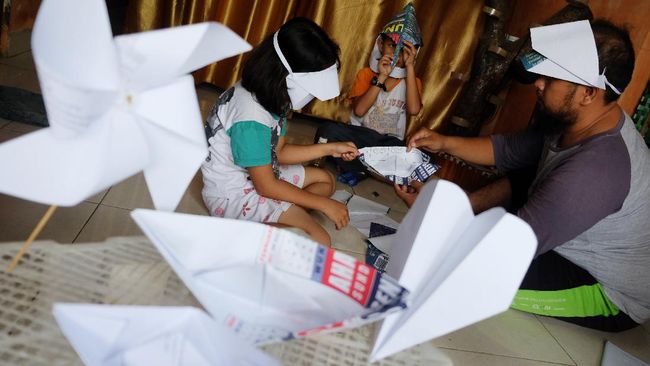 Dua siswa belajar seni melipat kertas (origami) bersama ayah mereka di rumahnya di Mojosongo, Solo, Jawa Tengah, Kamis (2/4/2020). Kegiatan belajar seni dari rumah tersebut dilakukan menyusul aturan Pemerintah Kota (Pemkot) Solo yang memperpanjang status Kejadian Luar Biasa (KLB) dengan meliburkan sekolah hingga 13 April 2020 mendatang, guna mengantisipasi penyebaran COVID-19. ANTARA FOTO/Maulana Surya/aww.