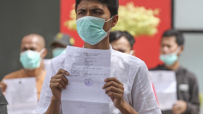 Warga binaan menunjukkan surat pembebasan di Rutan Kelas 1, Depok, Jawa Barat, Kamis (2/4/2020). Sebanyak 50 warga binaan di Rutan kelas 1 Depok dibebaskan dengan status asimilasi dalam rangka pencegahan dan penanggulangan penyebaran virus corona atau COVID-19. ANTARA FOTO/Asprilla Dwi Adha/aww.