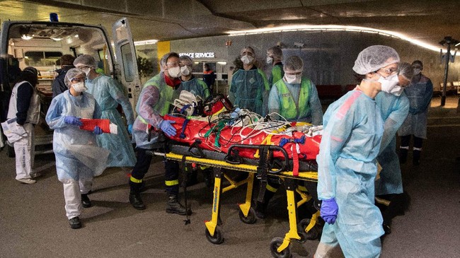 Medical staff disembark from ambulances patients infected with the COVID-19 at the Gare d'Austerlitz train station on April 1, 2020 in Paris as part of the evacuation of 36 patients in two separate medical TGV towards hospitals of Brittany, western France, where the outbreak of the Covid-19 pandemic caused by the novel coronavirus where has been limited so far. (Photo by Thomas SAMSON / POOL / AFP)
