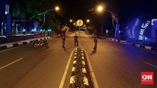 Riuh obrolan warung kopi di Aceh pudar akibat jam malam. Yang tersisa di malam hari hanya aparat dan pentungnya, mengingatkan warga masa darurat militer silam.