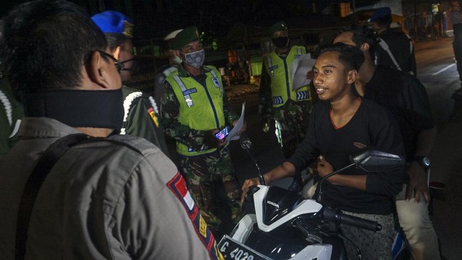 Petugas melaksanakan patroli saat pemberlakuan jam malam di Pekalongan, Jawa Tengah, Rabu (1/4/2020). Pemerintah Kota Pekalongan memberlakukan jam malam untuk membatasi aktivitas warga di luar rumah pada 1 April 2020 pukul 21.00 hingga 04.00 WIB sebagai upaya pencegahan penyebaran wabah virus Corona (COVID-19). ANTARA FOTO/Harviyan Perdana Putra/aww.