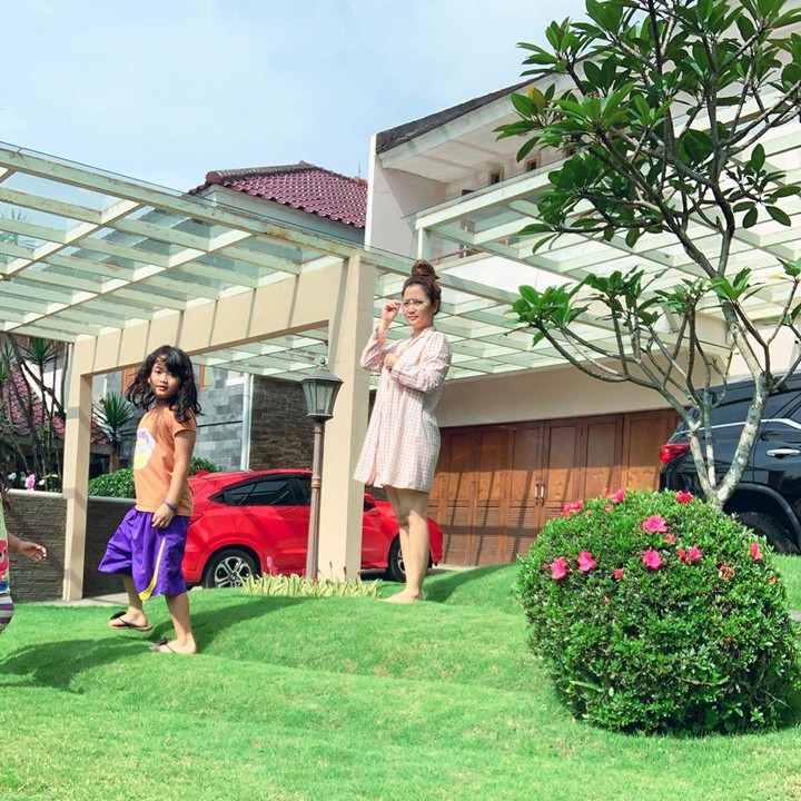 <p>Vega Darwanti mengunggah foto berjemur dengan dua anaknya di rumah. Halamannya luas dengan hamparan rumput hijau. Ada dua mobil terparkir di halaman rumahnya. (Foto: Instagram @vegadarwanti123)</p>