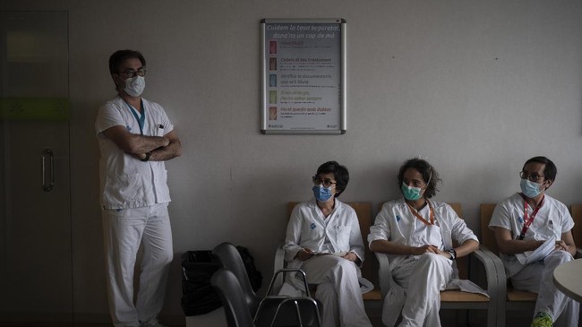 Healthcare workers gather during meeting to discuss COVID-19 procedures at Germans Trias i Pujol hospital in Badalona, Barcelona province, Spain, Wednesday, April 1, 2020. The new coronavirus causes mild or moderate symptoms for most people, but for some, especially older adults and people with existing health problems, it can cause more severe illness or death. (AP Photo/Felipe Dana)
