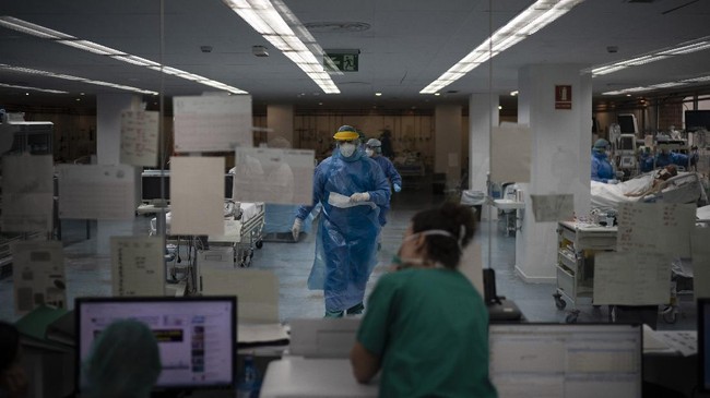 Healthcare workers assist COVID-19 patients at a library that was turned into an intensive care unit (ICU) at Germans Trias i Pujol hospital in Badalona, Barcelona province, Spain, Wednesday, April 1, 2020. The new coronavirus causes mild or moderate symptoms for most people, but for some, especially older adults and people with existing health problems, it can cause more severe illness or death. (AP Photo/Felipe Dana)