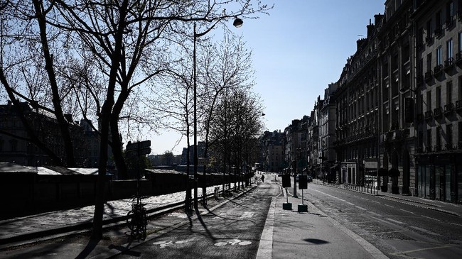 A cyclist is seen on an empty avenue in Paris on April 2, 2020 on the seventeenth day of a strict lockdown in France to stop the spread of COVID-19 (novel coronavirus). (Photo by Philippe LOPEZ / AFP)