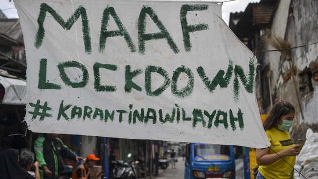 Warga melintas di dekat pengumuman karantina wilayah di kawasan Tambora, Jakarta, Jumat (3/4/2020) Warga setempat memberlakukan karantina wilayah secara mandiri dengan menutup beberapa akses jalan masuk perkampungan serta meningkatkan keamanan untuk mencegah penyebaran COVID-19. ANTARA FOTO/Nova Wahyudi/pras.