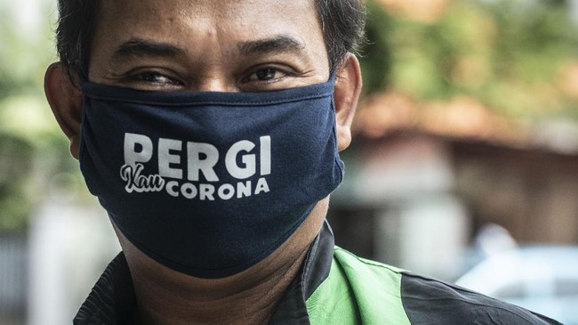 Pengemudi ojek daring menggunakan masker saat pembagian makanan gratis di kawasan Menteng, Jakarta, Jumat (3/4/2020). Pembagian makanan gratis tersebut merupakan sebagai bentuk kepedulian terhadap sesama di tengah-tengah pandemi COVID-19. ANTARA FOTO/Aprillio Akbar/pras.