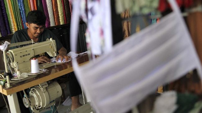 Perajin menjahit kain masker industri rumahan di Kecamatan Baruga, Kendari, Sulawesi Tenggara, Senin (6/4/2020). Sejak merebaknya wabah virus COVID-19 membuat penjahit pakaian beralih membuat masker kain untuk sementara waktu akibat meningkatnya permintaan dalam sehari bisa menjual masker hingga 250 lembar masker sementara penjualan melayani wilayah kota Kendari dan beberapa kabupaten di Sulawesi Tenggara. ANTARA FOTO/Jojon/hp.