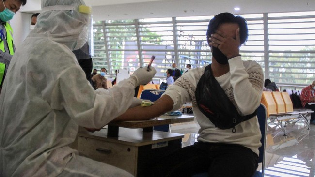 Sejumlah Pekerja Migran Indonesia (PMI) asal Malaysia menjalani Rapid Test saat tiba di kedatangan Internasional Terminal 2 Bandara Juanda, Sidoarjo, Jawa Timur, Selasa (7/4/2020). Sebanyak 156 Pekerja Migran Indonesia (PMI) dari Malaysia yang pulang ke Jawa Timur menjalani rapid test untuk pencegahan penyebaran corona virus atau COVID-19. ANTARA FOTO/Umarul Faruq/hp.
