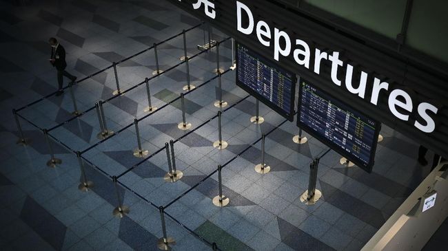 A man walks through a departure floor of the international terminal at Haneda airport in Tokyo on April 3, 2020. (Photo by CHARLY TRIBALLEAU / AFP)