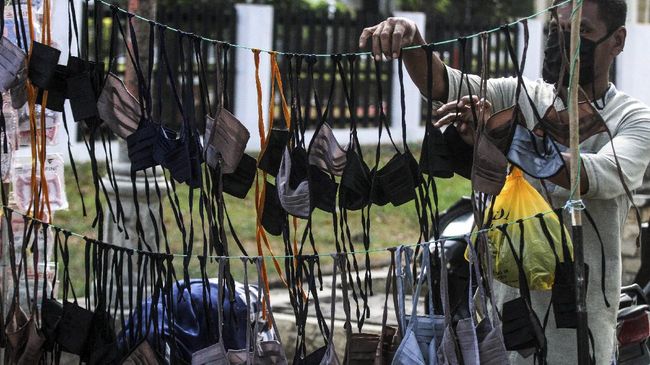 Pedagang menata masker berbahan kain di pinggir jalan di pusat Kota Lhokseumawe, Aceh, Selasa (31/3/2020). Penjualan masker berbahan kain buatan industri rumahan yang dijual Rp10 ribu permasker itu laku keras menyusul kesulitan warga mendapatkan masker kesehatan untuk mencegah terjangkit virus Corona (COVID-19). ANTARA FOTO/Rahmad/wsj.