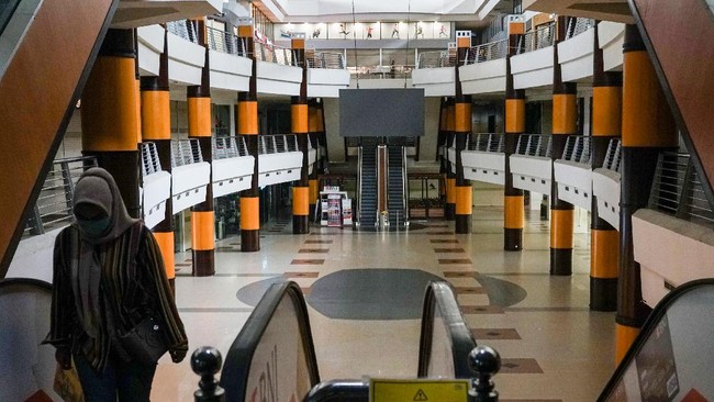 Warga melintas di pertokoan yang tutup di Duta Mall Banjarmasin, Kalimantan Selatan, Selasa (7/4/2020). Marketing Komunikasi Duta Mall memperpanjang masa penutupan sementara hingga tanggal 15 April 2020 sebagai upaya mencegah penyebaran wabah COVID-19. ANTARA FOTO/Makna Zaezar/hp.