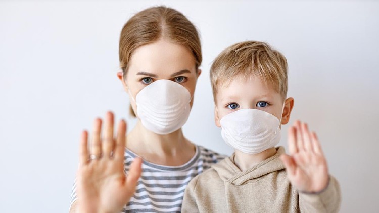 Adult woman and little boy in medical masks showing stop gesture and looking at camera during coronavirus epidemic against gray background