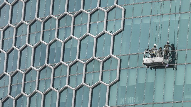 Pekerja membersihkan kaca sebuah gedung bertingkat di Jakarta, Senin (23/3/2020). Menteri Keuangan Sri Mulyani menyatakan proyeksi pertumbuhan ekonomi tahun ini diperkirakan tumbuh empat persen serta prediksi terburuk hanya mampu tumbuh 2,5 persen dan bahkan nol persen sebagai dampak wabah virus corona (COVID-19). ANTARA FOTO/Muhammad Adimaja/aww.