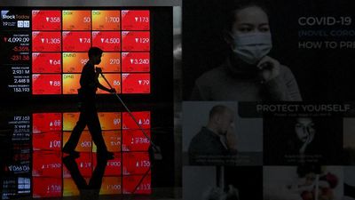 Petugas kebersihan melintas di depan layar yang menampilkan pergerakan saham di gedung Bursa Efek Indonesia, Jakarta, Kamis (19/3/2020). Indeks Harga Saham Gabungan (IHSG) melemah pada penutupan sesi 