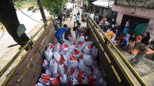 Petugas dibantu warga menurunkan paket sembako yang diberikan Kementerian Sosial (Kemensos) kepada warga yang membutuhkan di kawasan Kebon Baru, Tebet, Jakarta, Rabu (8/4/2020). Kemensos mendistribusikan 200 ribu paket sembako dan makanan siap saji untuk pekerja sektor informal di wilayah zona merah COVID-19. ANTARA FOTO/Indrianto Eko Suwarso/foc.