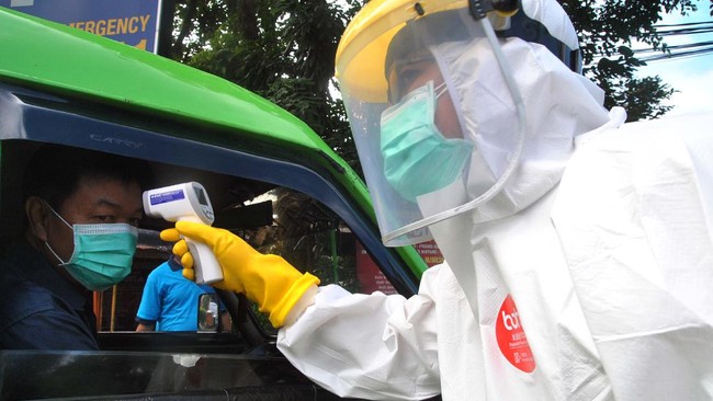 Petugas Dinkes Kota Bogor dengan mengenakan pakaian Alat Pelindung Diri (APD) lengkap memeriksa suhu tubuh sopir angkot di Simpang Air Mancur, Kota Bogor, Jawa Barat, Rabu (8/4/2020). Dishub Kota Bogor bersama Dinkes Kota Bogor memeriksa suhu tubuh sopir dan penumpang angkot di sejumlah ruas jalan utama sebagai upaya antisipasi penyebaran virus Corona (COVID-19) yang meningkat di Kota Bogor. ANTARA FOTO/Arif Firmansyah/aww.