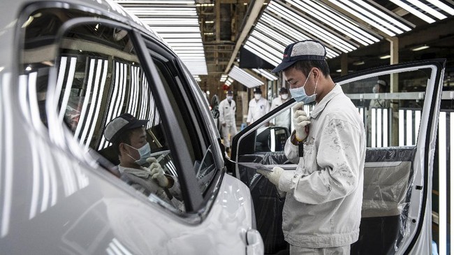 This photo taken on April 7, 2020 shows an employee wearing a face mask working on an assembly line at an auto plant of Dongfeng Honda in Wuhan in China's central Hubei province. - Thousands of relieved citizens streamed out of China's Wuhan on April 8 after authorities lifted months of lockdown at the coronavirus epicntre, offering some hope to the world despite record deaths in Europe and the United States. (Photo by STR / AFP) / China OUT