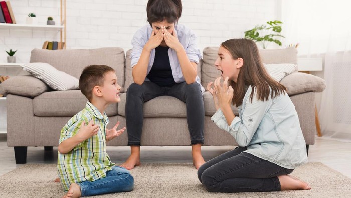 Problems of motherhood. Mom is depressed by screaming children, siblings having quarrel