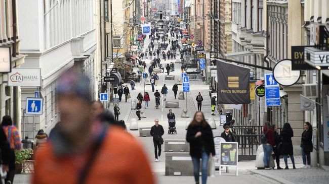 In this photo taken on March 27, 2020, people go about their daily routing, on Drottninggatan, the main shopping street in Stockholm, Sweden, amid the new coronavirus COVID-19 pandemic. The coronavirus is not keeping people in Sweden at home even while citizens in many parts of the world are sheltering in place. Swedes still sit at outdoor cafes in the center of Stockholm. (Henrik Montgomery/TT News Agency via AP)