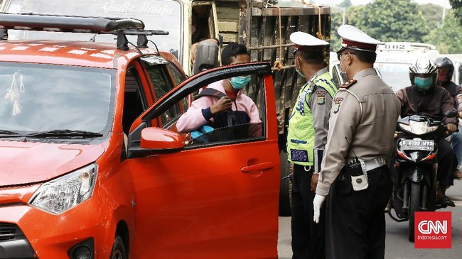 Aparat polri bersama dishub melakukan pemeriksaan pengendara roda dua dan empat di Jalan Ciputat Raya, Jakarta Selatan,  pemeriksaan bertujuan menghimbau pengendara untuk menggunakan masker dan peraturan posisi duduk dan jumlah penumpang selama PSBB. Jakarta. Jumat (10/4/2020). Polda Metro Jaya membangun 20 titik pos di perbatasan Jakarta untuk mengawasi kendaraan yang keluar masuk Ibu Kota selama masa pembatasan sosial berskala besar atau PSBB. CNN Indonesia/Andry Novelino