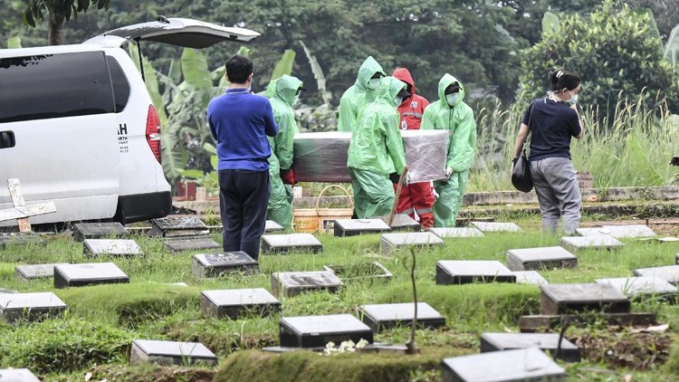 Petugas pemakaman membawa peti jenazah pasien COVID-19 di TPU Pondok Ranggon, Jakarta, Senin (30/3/2020). Juru bicara pemerintah untuk penanganan COVID-19 Achmad Yurianto per Senin (30/3/2020) pukul 12.00 WIB menyatakan jumlah pasien positif COVID-19 di Indonesia telah mencapai 1.414  kasus, pasien yang telah dinyatakan sembuh sebanyak 75 orang, sementara kasus kematian bertambah delapan orang dari sebelumnya 114 orang menjadi 122 orang.
