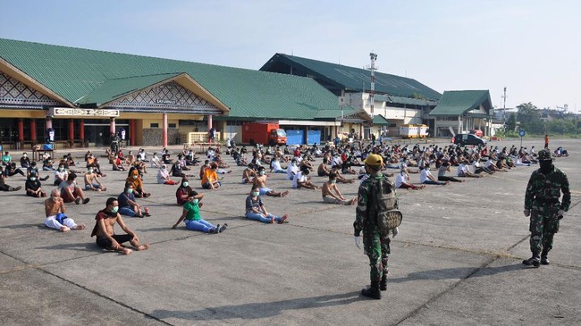 Sejumlah Tenaga Kerja Indonesia (TKI) asal Malaysia mengikuti senam dan berjemur di bawah sinar matahari saat menjalani karantina di Pangkalan Udara Militer (Lanud) Soewondo Medan, Sumatera Utara, Sabtu (11/4/2020). Sebanyak 513 TKI yang berasal dari berbagai daerah di Sumut dan sekitarnya yang menjalani proses karantina COVID-19 sementara tersebut saat ini kondisi kesehatannya baik dan tidak ada menunjukan gejala infeksi seperti demam, batuk dan sesak nafas. ANTARA FOTO/Septianda Perdana/hp.