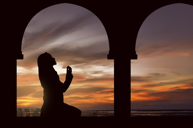 Silhoutte of muslim woman praying during fasting holy month of ramadan