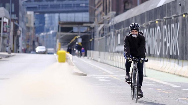 NEW YORK, - MARCH 18: A cyclist wearing a mask is seen as the coronavirus continues to spread across the United States on March 18, 2020 in New York City. The World Health Organization declared coronavirus (COVID-19) a global pandemic on March 11th.   Dimitrios Kambouris/Getty Images/AFP