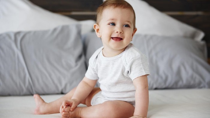 Portrait of confused baby lying on the bed