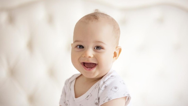Portrait of confused baby lying on the bed