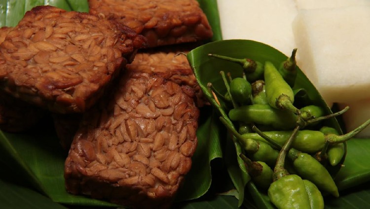 Tempe Bacem, the traditional Javanese dish of tempeh (soy bean cake) braised in soy sauce. A popular accompaniment for many other Javanese dish, such as with Jadah, the glutinous rice and coconut cake. The dish are placed on a woven bamboo tray lined with banana leaf. Jadah tempe are eaten with fresh green chili pepper.