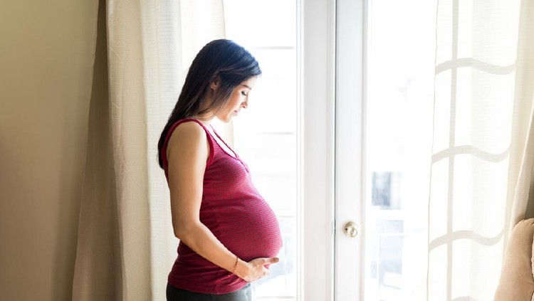 beauty pregnant woman smile and think something at home