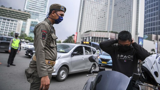 Satpol PP meminta pengendara motor mengenakan masker saat pemeriksaan kepatuhan Pembatasan Sosial Berskala Besar (PSBB) di kawasan Bundaran HI, Jakarta, Senin (13/4/2020). Pemeriksaan tersebut untuk memastikan setiap pengendara mobil dan motor mematuhi aturan PSBB yang diterapkan di DKI Jakarta. ANTARA FOTO/Hafidz Mubarak A/wsj.