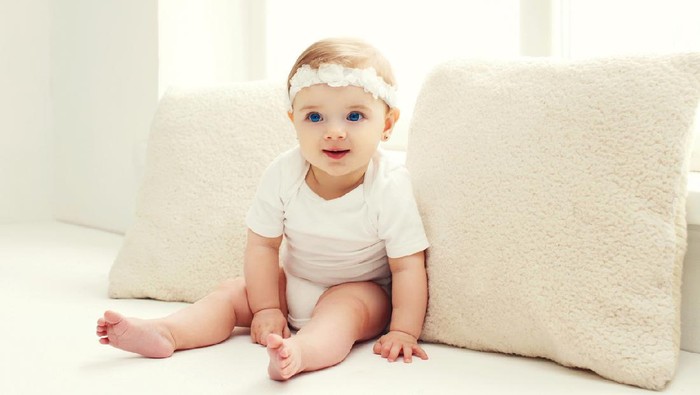 Portrait of confused baby lying on the bed
