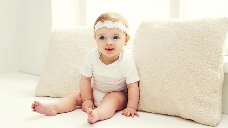 Portrait of confused baby lying on the bed