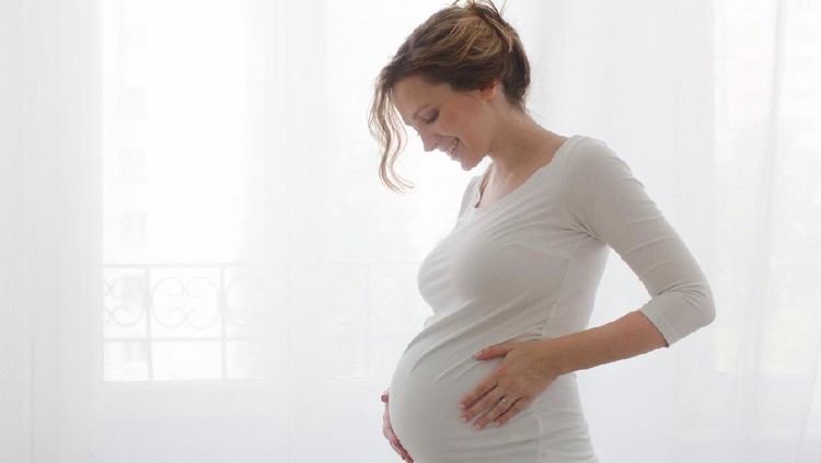 beauty pregnant woman smile and think something at home