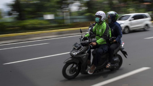 Pengemudi ojek daring membonceng penumpang saat melintas di kawasan Kramat Raya, Jakarta, Senin (13/4/2020). Pelaksana tugas (Plt) Menteri Perhubungan Luhut Pandjaitan mengizinkan ojek daring mengangkut penumpang selama masa Pembatasan Sosial Berskala Besar (PSBB) di Jakarta, namun dengan ketentuan harus memenuhi protokol kesehatan yang ditetapkan. ANTARA FOTO/M Risyal Hidayat/wsj.
